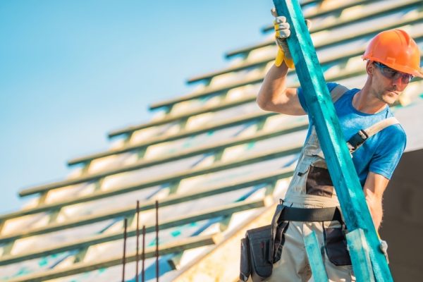 Roof Construction Wood. Caucasian Roofer with Wooden Building Structure Element. House Construction Site.